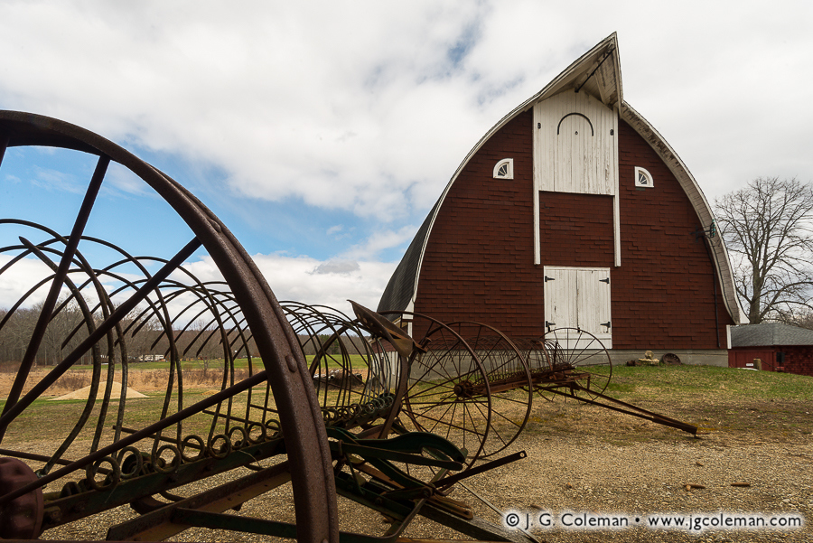 Yankee Farmlands № 59 (Old plows beside ornate round-roof barn, Colchester, Connecticut)